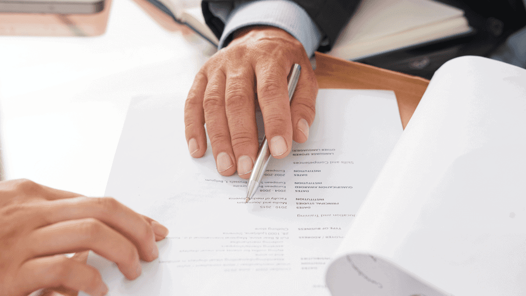 Two people at a desk going over a printed document together