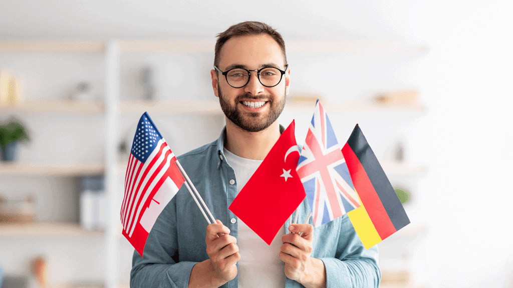 A man holding a handful of different national flags
