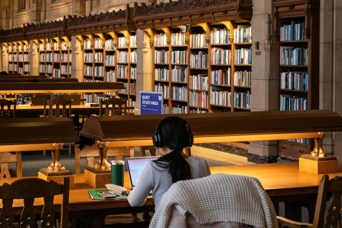 Student studies at a library with books
