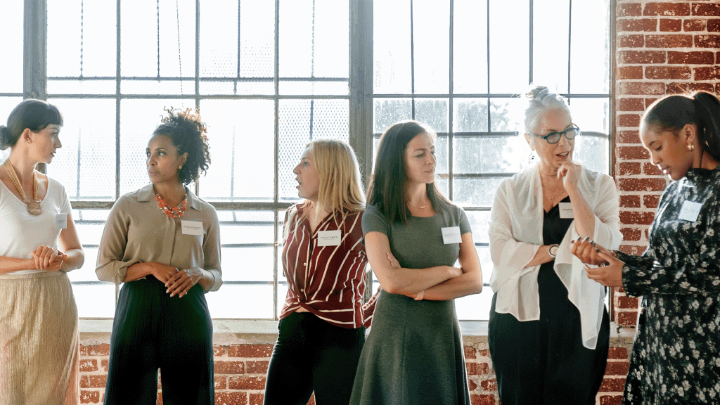 A group of women in name badges talking at a networking event