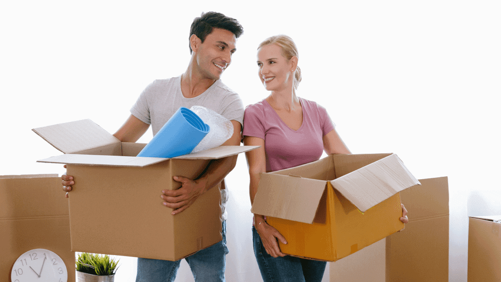 A couple carrying packing boxes between them