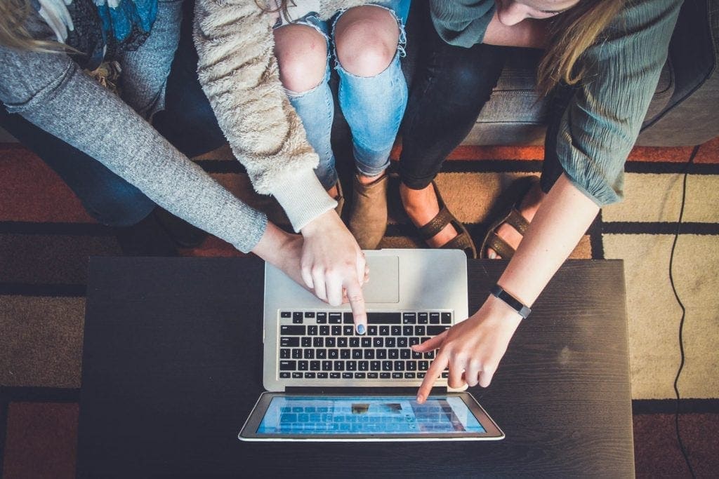 Several people gathered around a laptop, seen from above