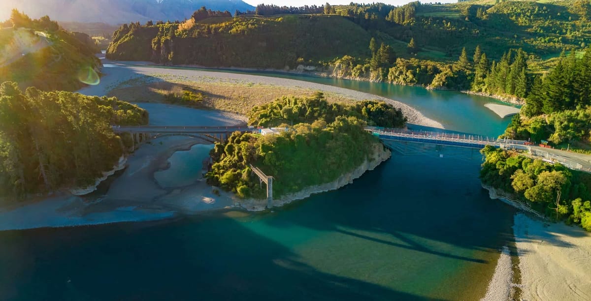 Aerial view of a river bend and footbridge through native bush