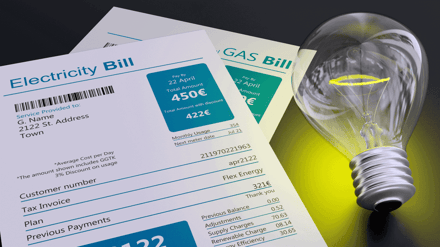 Electricity and gas bills fanned out beside a lightbulb