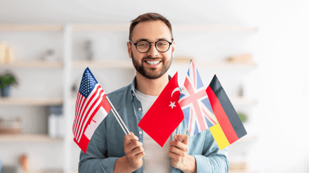 A man holding a handful of different national flags