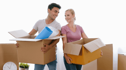 A couple carrying packing boxes between them