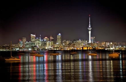 The Auckland skyline at night reflected in the harbour
