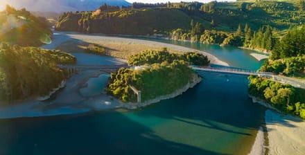 Aerial view of a river bend and footbridge through native bush